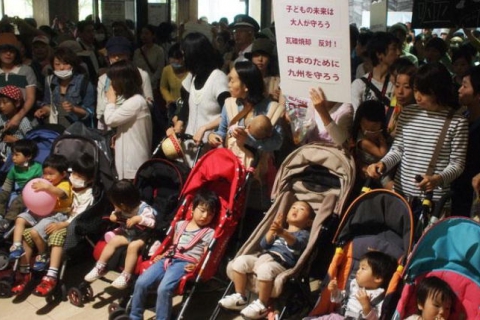 japan_mothers_with_children_against_buring_rubble_in_kitakyushu_city_kitakyusyu.jpg