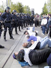 Non-violent demonstrators lie down in front of riot police