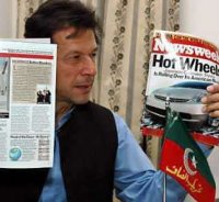 Pakistani cricket legend turned politician Imran Khan shows copies of the magazine during a news con