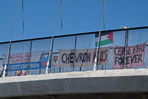 Coordinated Banner Drops Support BDS Movement's Call for Chevron Boycott
