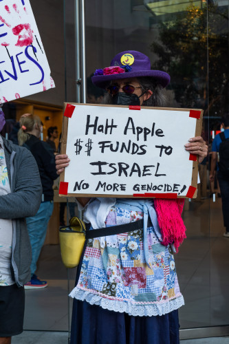 Woman in apron with sign: Halt Apple Funds to Israel