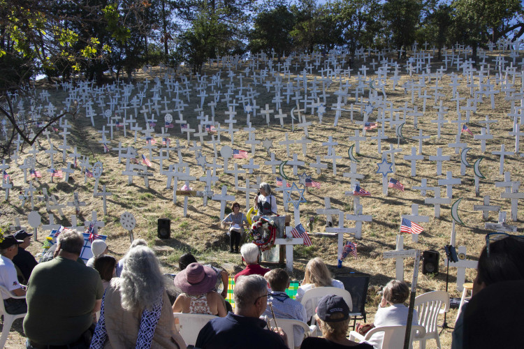 A community gathers at the foot of the hillside on Memorial Day 2024