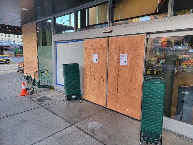 photograph of entrance doors boarded up with plywood