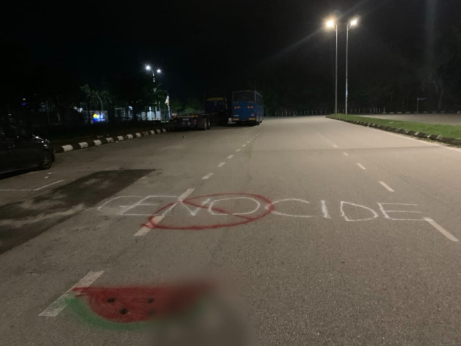 Nighttime photo of a road with pro Palestine spraypainted messages