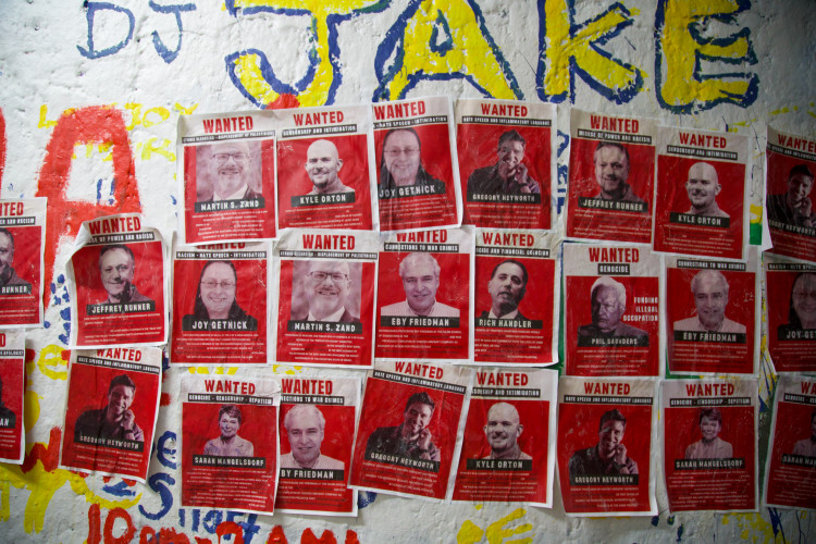 A photo of some of the WANTED posters pasted on a wall.