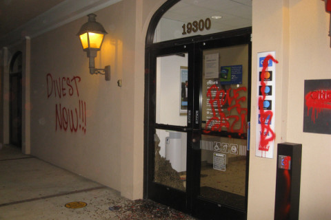 citibank office front vandalized with front window broken, "DIVEST NOW!!" and "FREE GAZA" spray painted.